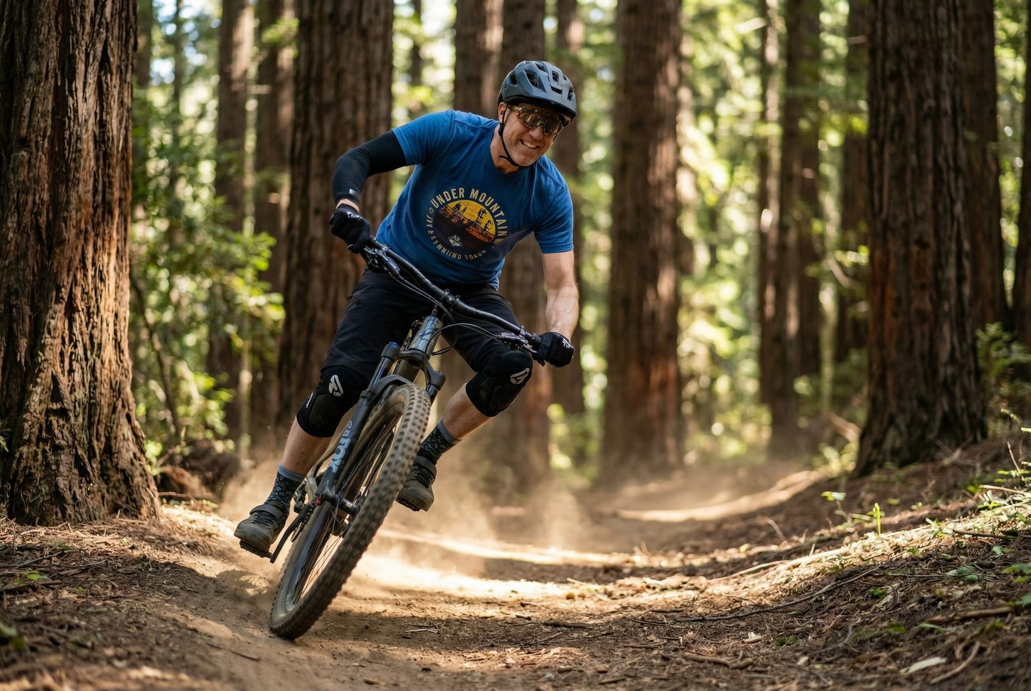Brian riding a mountain bike through a redwood forest